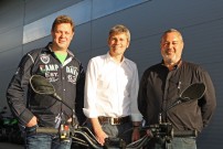 Henning Löw (links, Reaction Deutschland) und Elmar Steck (rechts, Außendienst Koch Zweirad Vertrieb) nehmen Kai Friedrichsen in ihrer Mitte als Vertriebs-Leiter bei Koch Zweirad auf